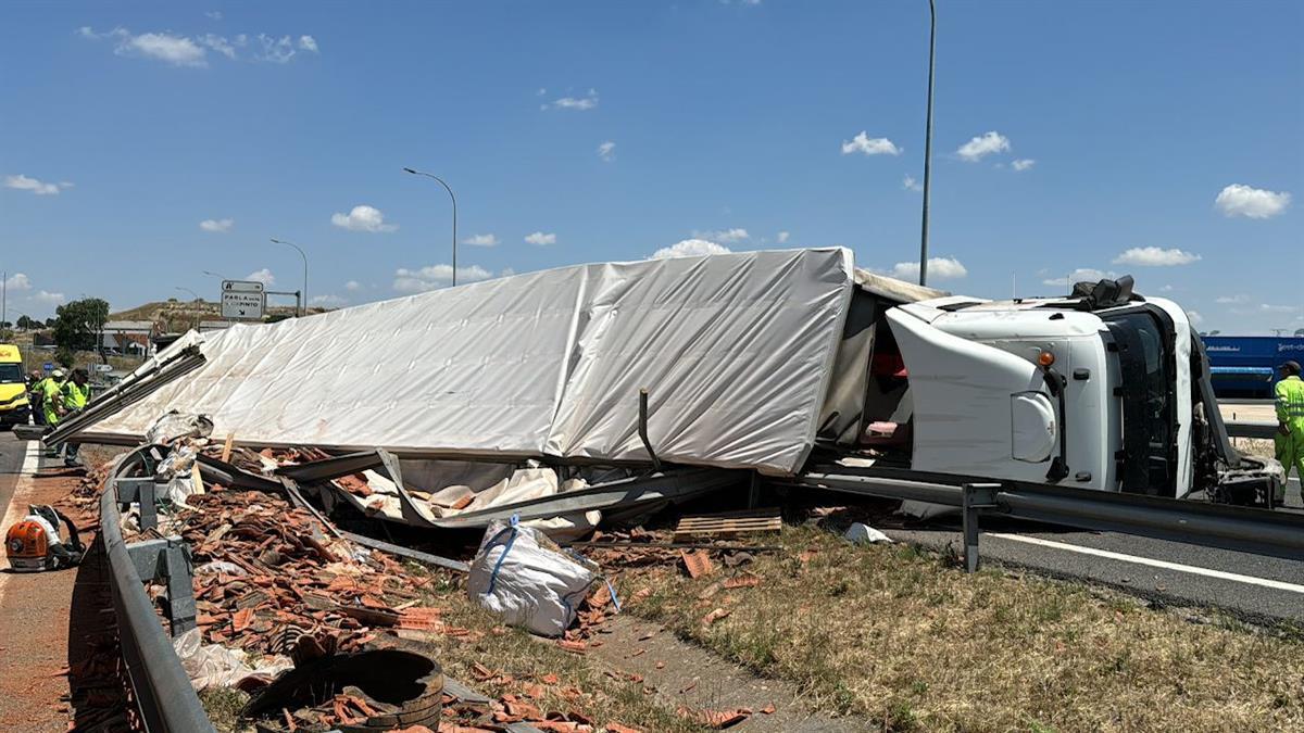 El vehículo ha volcado y ha dejado parte de su carga de tejas en uno de los carriles